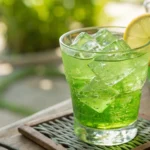 Close-up of a green tea shot in a shot glass with a lemon garnish